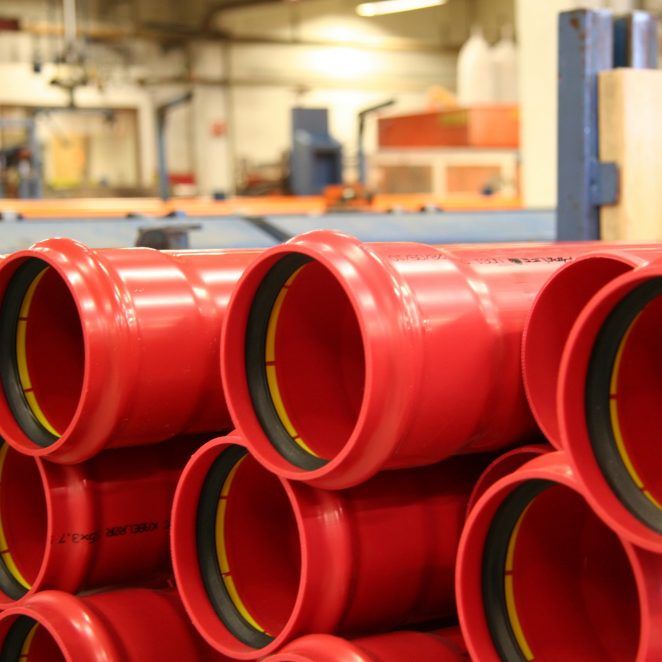 Cable protection tubes red, in production hall