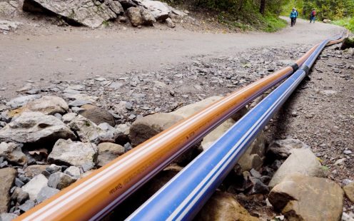 Two PE 100-RC coated pressure pipes lying along a hiking trail in Tatra National Park.