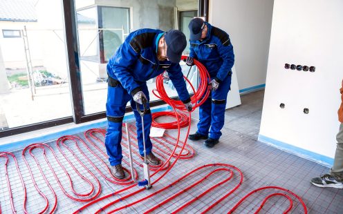 Two people installing prefab underfloor heating mats in single family home | Pipelife 