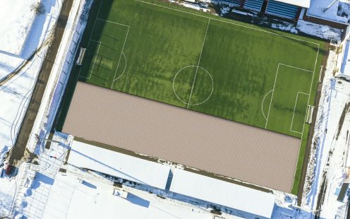 top view of empty green soccer field in winter time. drone photography