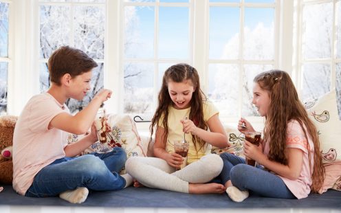 Children Sitting On Window Seat Eating Ice Cream Sundaes