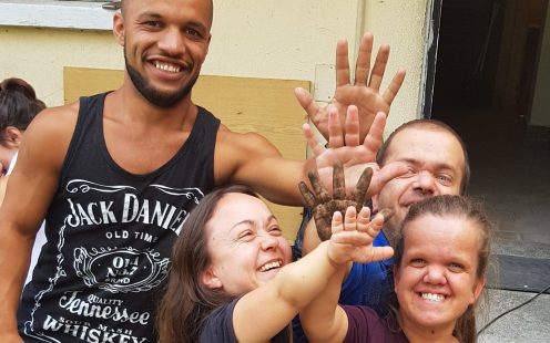 Five members of "The Little People of Bulgaria" association give high five to each other in front of the entrance of the service center | Pipelife