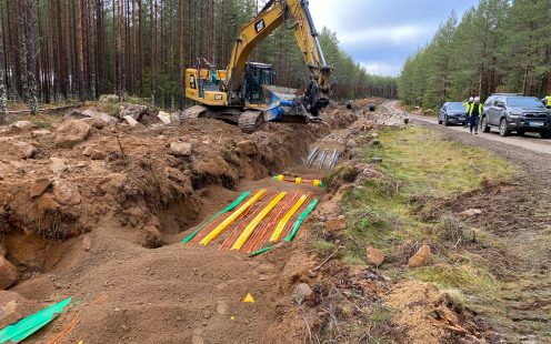 An excavator closing a shallow trench with several cable protection pipes laid | Pipelife