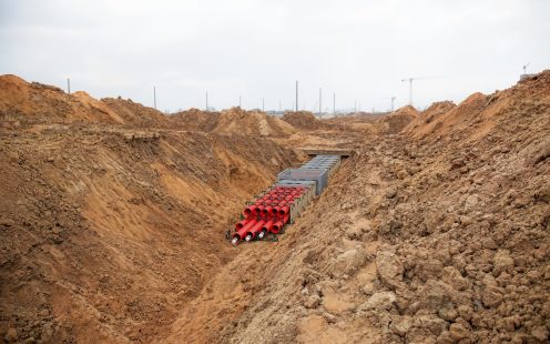 A 3D visualization of a duct bank system being installed in an open trench. 