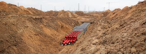 A 3D visualization of a duct bank system being installed in an open trench. 