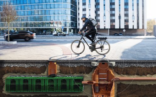Male cyclist in the city. Rain drainage system reveal with smart sensor.