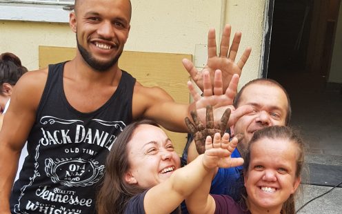 Five members of "The Little People of Bulgaria" association give high five to each other in front of the entrance of the service center | Pipelife