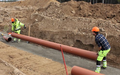 Two installers laying down a Biovyn wastewater pipe | Pipelife