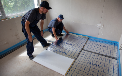Martin Dimitrov installing the prefabricated underfloor heating mats in his house together with a plumber | Pipelife