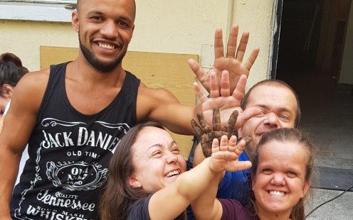 Five members of "The Little People of Bulgaria" association give high five to each other in front of the entrance of the service center | Pipelife