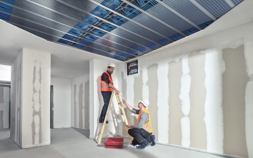 Two installers setting up a radiant cooling system in the ceiling | Pipelife
