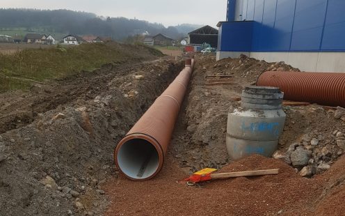 Corrugated drainage pipes in an open trench next to the production site | Pipelife