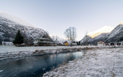 A small frozen river in the mountains,  running along a small mountain village | Pipelife