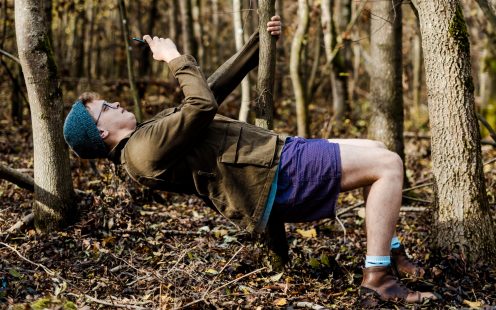 A young guy leaning back to take a photo of a tree from an unusual angle | Pipelife 