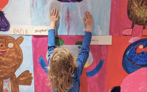 A young girl is putting up her drawing on a wall at SOS Kinderdorf village in Austria | Pipelife
