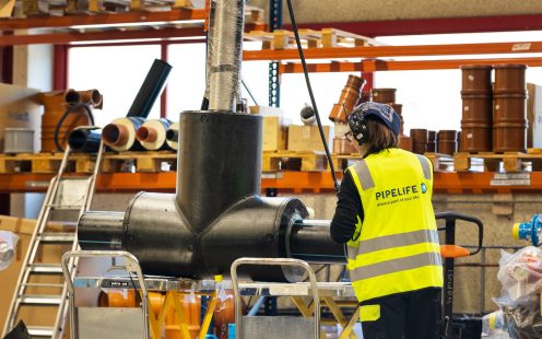 A worker is standing next to a pre-insulated fire hydrant at Pipelife Norway's plant | Pipelife