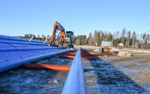 An excavator arranging several Robust pipes in line for installation | Pipelife