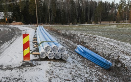 A pile of seven Pipelife Robust pipes next to a roll of PE water supply pipe | Pipelife