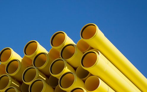 Yellow PVC cable protection pipes against a bright blue sky.