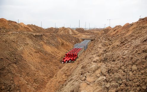 A 3D visualization of a duct bank system being installed in an open trench. 