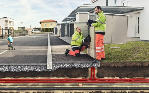 A 3D visualization showing two electricians in a residential area near a distribution board with several cable ducts revealed under the ground.