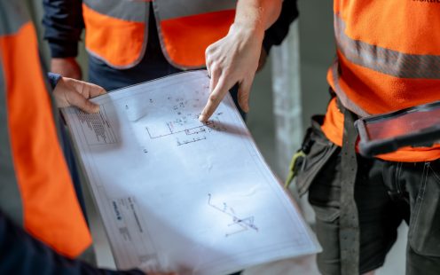 Three installers reviewing an installation plan.