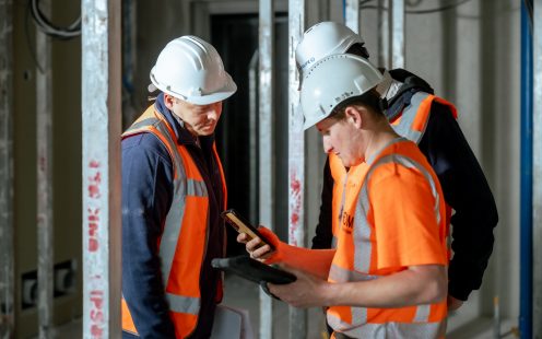Three installers reviewing installation plans on their portable devices.