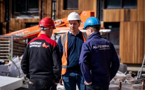 Three building technicians standing at the Octaaf construction site.