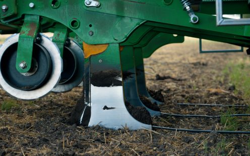 A drip tape is installed under the surface using specialized machinery.