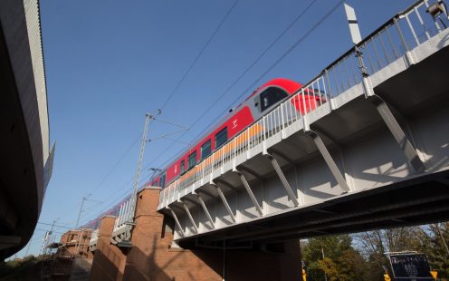 Train passes over railway bridge on the E59 line in Poland | Pipelife